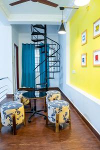 een kamer met een tafel en stoelen en een wenteltrap bij Fiji Villa in Pondicherry