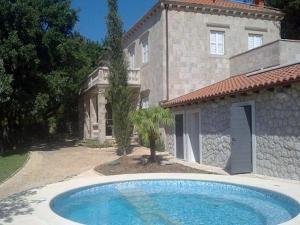 a large swimming pool in front of a house at Exclusive Villa with private pool huge fenced property near Dubrovnik in Čilipi