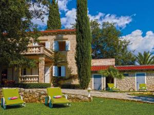 a house with two lawn chairs in front of it at Exclusive Villa with private pool in Dubrovnik in Čilipi