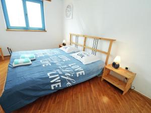 a bedroom with a bed with a blue comforter and a table at Lovely Villa in Ka telir Croatia with Private Pool in Labinci