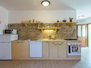 a kitchen with white appliances and a brick wall at Apartment in Istria with Nature Views in Cerovlje