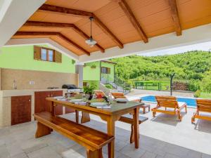 a kitchen and dining room with a table and a pool at Apartment in Istria with Nature Views in Cerovlje