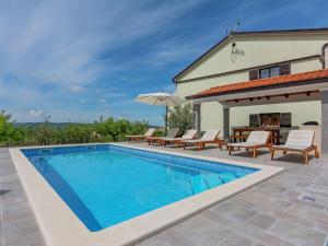 a swimming pool with chairs and a house at Apartment in Istria with Nature Views in Cerovlje +22 photos
