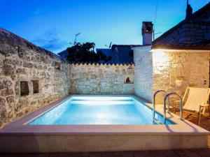 a swimming pool in a building with a stone wall at Cosy holiday home in Vrsar with private pool in Marasi