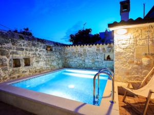 a large swimming pool in a stone building with at Cosy holiday home in Vrsar with private pool in Marasi