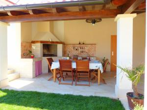 eine Terrasse mit einem Tisch und Stühlen sowie eine Küche in der Unterkunft Cozy Holiday Home in Valtura with Swimming Pool in Valtura