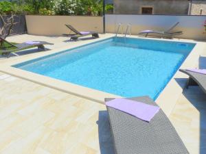 a swimming pool with two chairs and a table at Cozy Holiday Home in Valtura with Swimming Pool in Valtura