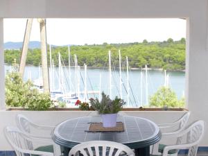 a table and chairs on a balcony with boats in the water at Charming Holiday House in a quiet area large covered terrace with great sea view in Veli Rat