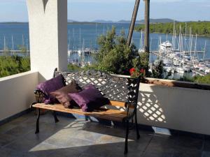 - un banc sur un balcon avec vue sur le port dans l'établissement Charming Holiday House in a quiet area large covered terrace with great sea view, à Veli Rat