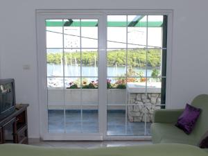 a living room with a sliding glass door at Charming Holiday House in a quiet area large covered terrace with great sea view in Veli Rat