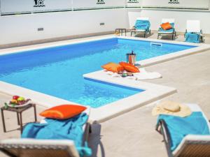 une piscine avec des chaises et une piscine dans l'établissement Modern villa with private pool and bubble bath, à Novigrad