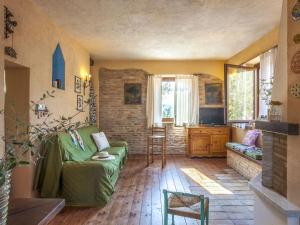 un soggiorno con divano verde e tavolo di Belvilla by OYO Le Castorelle a Montemaggiore al Metauro