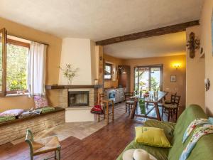 un soggiorno con divano verde e una cucina di Belvilla by OYO Le Castorelle a Montemaggiore al Metauro