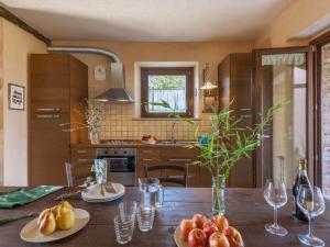 una cucina con tavolo in legno e piatti di frutta di Belvilla by OYO Le Castorelle a Montemaggiore al Metauro