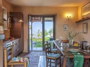 una cucina con tavolo, sedie e porta aperta di Belvilla by OYO Le Castorelle a Montemaggiore al Metauro