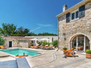 a backyard with a swimming pool and a house at Rustic villa in Vrsar with private swimming pool in Marasi