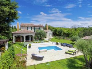 a backyard with a swimming pool and a house at Lush Villa with Artistic Interiors Pool in Baderna