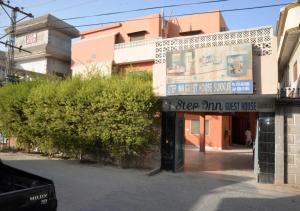 un bâtiment avec un panneau sur le côté d'une rue dans l'établissement Step inn Guest House Sukkur, à Kalar Goth