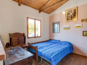 Un dormitorio con una cama azul y una mesa en Belvilla by OYO Casa Andrea, en Sparti
