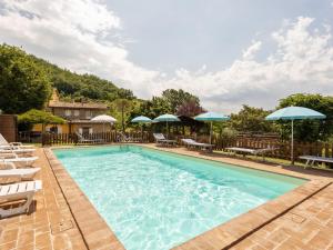 アッシジにあるApartment in Assissi with Terrace Garden Swimming Poolの大型スイミングプール(椅子、パラソル付)