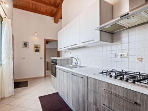 cocina con fregadero y fogones horno superior en Belvilla by OYO Villa Manca, en Santa Giusta