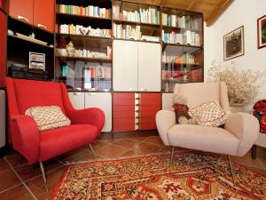 ein Wohnzimmer mit 2 Stühlen und Bücherregalen in der Unterkunft Belvilla by OYO Cozy Holiday Home with Pool in Carbuta