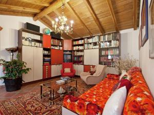 ein Wohnzimmer mit einem Sofa, Stühlen und Bücherregalen in der Unterkunft Belvilla by OYO Cozy Holiday Home with Pool in Carbuta