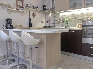 a kitchen with a counter and stools in it at Belvilla by OYO Villa Valtopina in Valtopina
