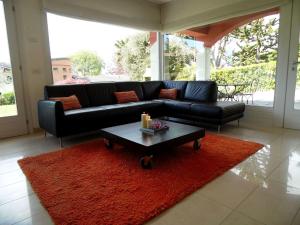 un soggiorno con divano nero e tappeto rosso di Belvilla by OYO Varese Quattro a Comerio