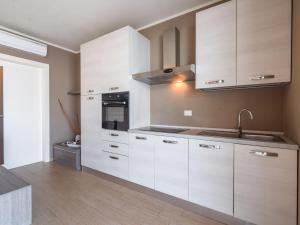 a kitchen with white cabinets and a sink at Belvilla by OYO Casa Giada in Marone