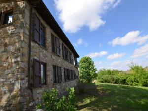 an old stone building with a green yard at Belvilla by OYO Casa Magnano Ziano in Ziano Piacentino