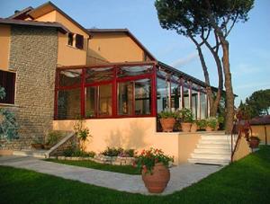 una casa con molte finestre e piante in vaso di B&B Villa Acero a Marina di Carrara