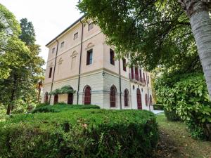 a large building with red windows and a tree at Belvilla by OYO Villa Fiorita Due in Romano D'Ezzelino