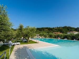 MontinelleにあるSerene Apartment in Manerba del Garda with Poolの木々が茂るリゾート内の大型スイミングプール