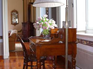 a wooden desk with a vase of flowers on it at Dreamy Castle near Padua and Venice with Royal Ambience in Monselice