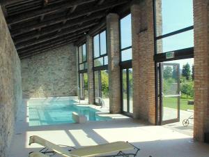 a swimming pool in a brick building with windows at Dreamy Castle near Padua and Venice with Royal Ambience in Monselice