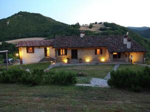 a stone house with lights in the yard at Bright Holiday Home in Modigliana with Swimming Pool in Modigliana