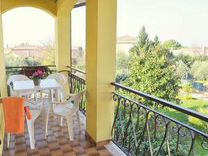 a balcony with a table and chairs and a view at Belvilla by OYO Argentina Cinque in Lazise