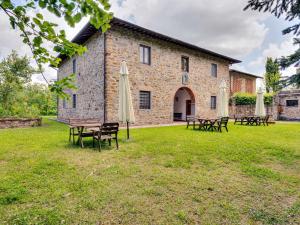 un groupe de tables et de parasols devant un bâtiment dans l'établissement Belvilla by OYO Nimphaea, à Greve in Chianti