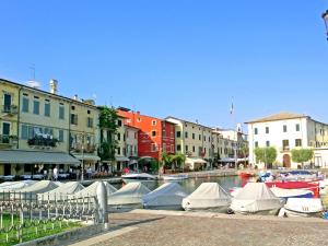 a group of boats docked in a canal with buildings at Belvilla by OYO Argentina Cinque in Lazise
