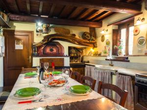 a kitchen with a table with green plates and wine glasses at Belvilla by OYO Villa Luciana in Piteccio