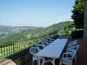 a white table and chairs on a balcony with mountains at Holiday home in Dicomano FI in Dicomano