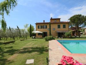 an external view of a house and a swimming pool at Farmhouse with private terrace, garden and pool, overlooking the town of Cortona in Cortona