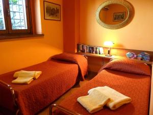 タヴァルネッレ・ヴァル・ディ・ペーザにあるLush Holiday Home in Tavarnelle Val di Pesa with Shared Poolのベッド2台と鏡が備わるホテルルームです。