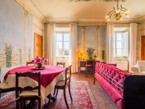 MontecastelliにあるBelvilla by OYO Affreschiの赤いテーブルとソファ付きのダイニングルーム