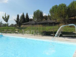 a swimming pool with a water fountain at Belvilla by OYO Villa Rapolano in Rapolano Terme
