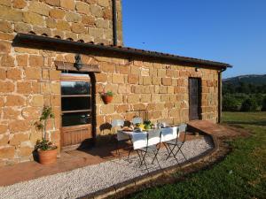 une table et des chaises devant un bâtiment en briques dans l'établissement Belvilla by OYO Piano, à Sorano