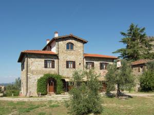 Poggio Alla CroceにあるBelvilla by OYO Sangioveseの木の前の古い石造家