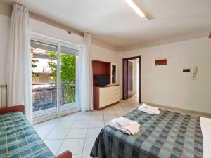 - une chambre avec un lit et une grande fenêtre dans l'établissement Premium Apartment in Rimini with Balcony, à Rimini