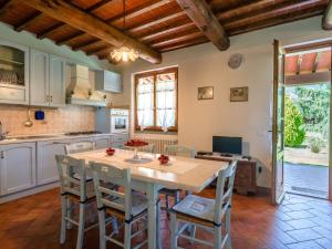 Una cocina con una gran mesa y sillas de madera. en Charm farmhouse with pool, en Castiglion Fiorentino